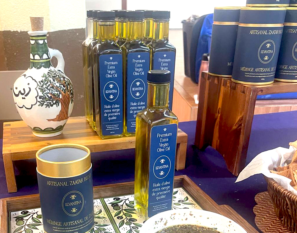 Bouteilles d'huile d'olive haut de gamme Levantina et boîtes de zaatar artisanal disposées sur une table de présentation